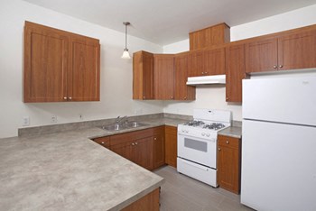 Polo Villas Two Bedroom Kitchen with Thermofoil Woodgrain Cabinets and White Appliances in select apartments - Photo Gallery 26