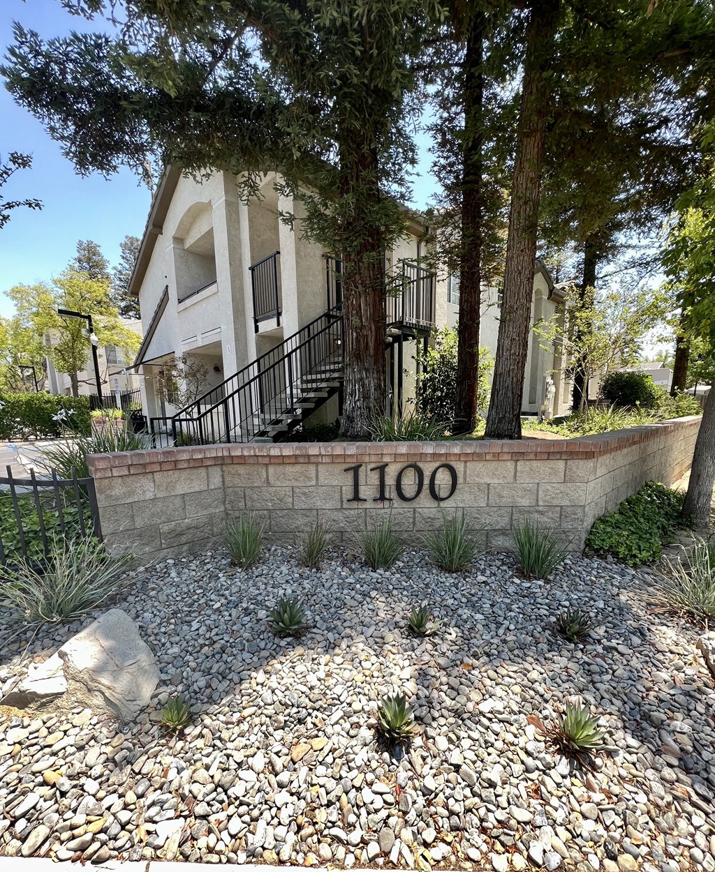 a house with a stone wall with the number 100 on it  at Villa Mondavi, Bakersfield, California