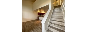 a view from the top of the stairs looking into the kitchen and living room  at Polo Villas, Bakersfield, CA