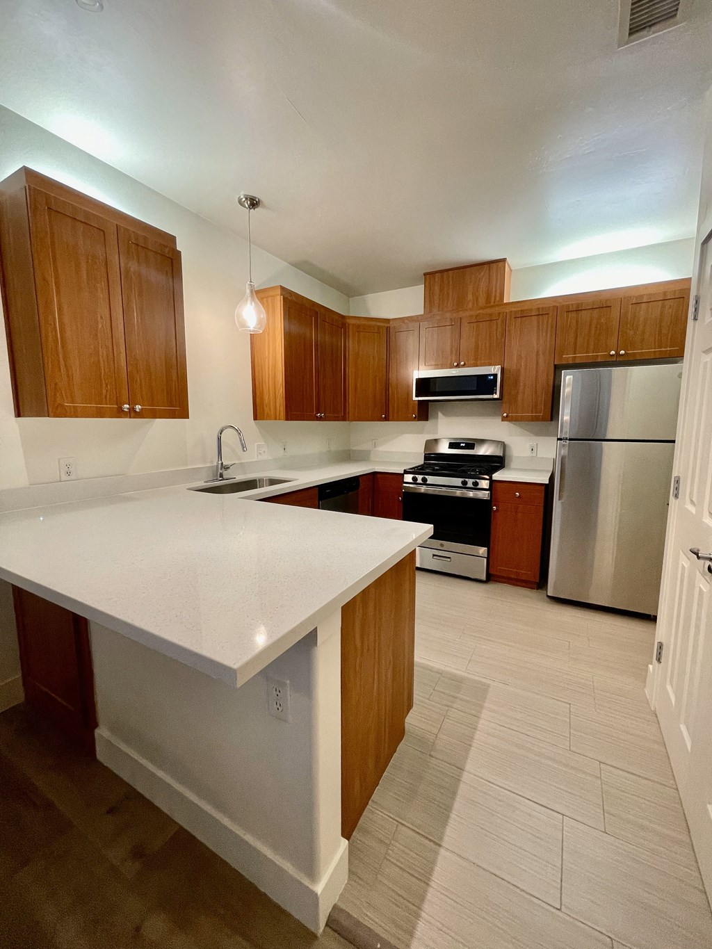 a kitchen with white countertops and wooden cabinets  at Polo Villas, California