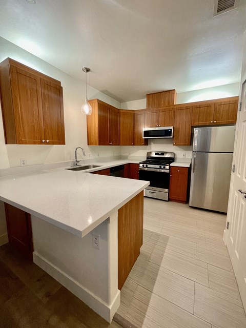 a kitchen with white countertops and wooden cabinets  at Polo Villas, California
