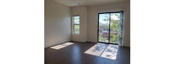 an empty living room with a sliding glass door and a view of the city  at Roundhouse Place, San Luis Obispo, 93401