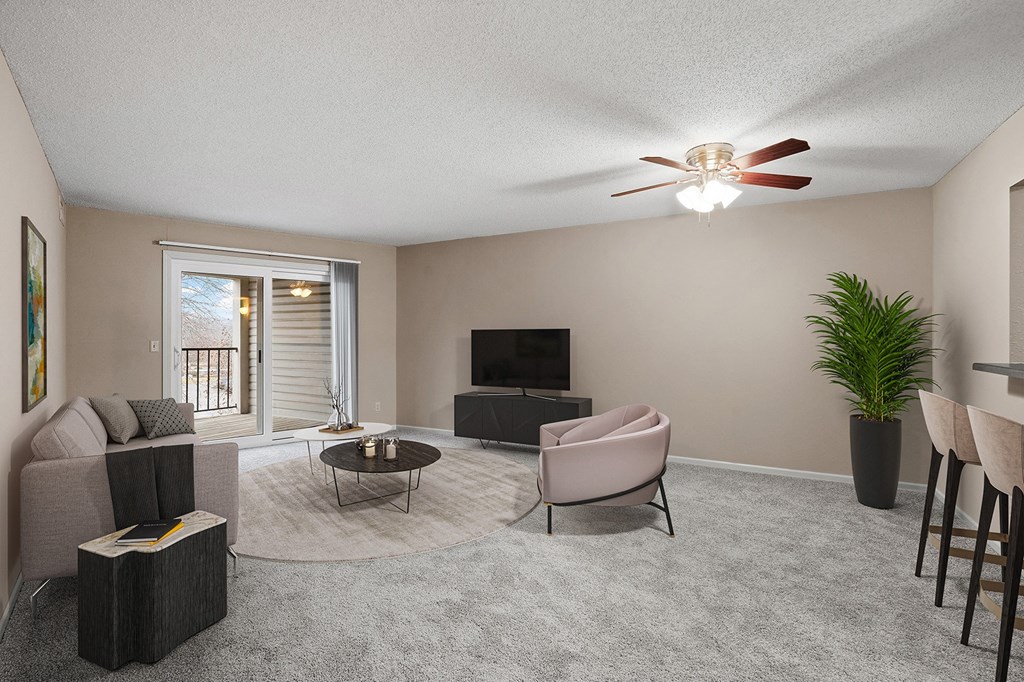 a living room with a couch and a chair and a ceiling fan