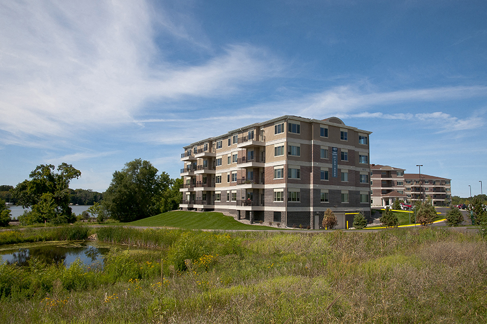 an apartment building on a hill overlooking a body of water