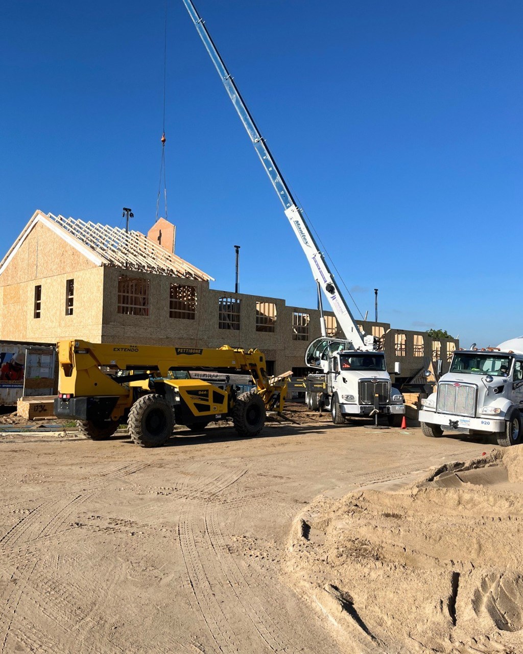 A yellow crane is in front of a building.