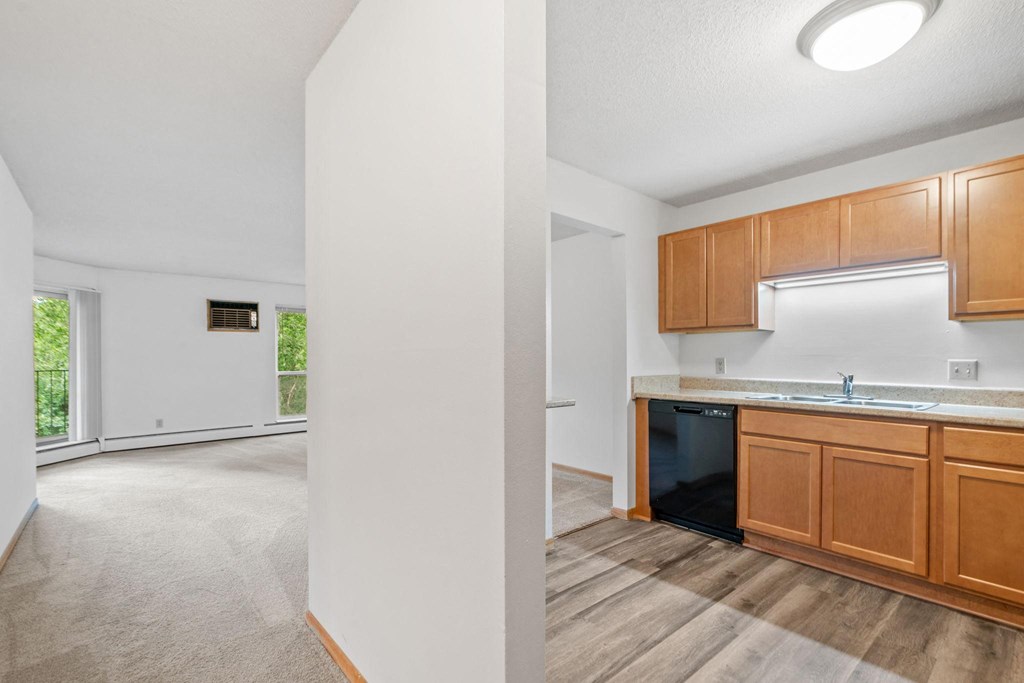 a kitchen and living room with wood flooring and white walls