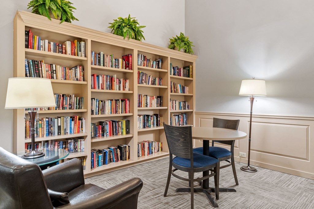 a library with a table and chairs and shelves of books