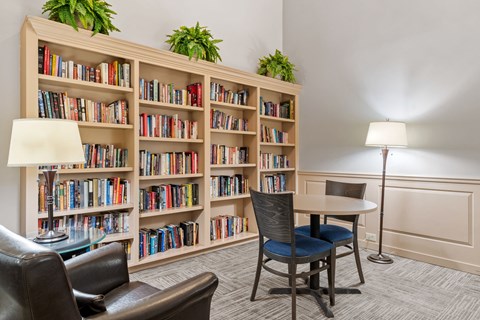 a library with a table and chairs and shelves of books
