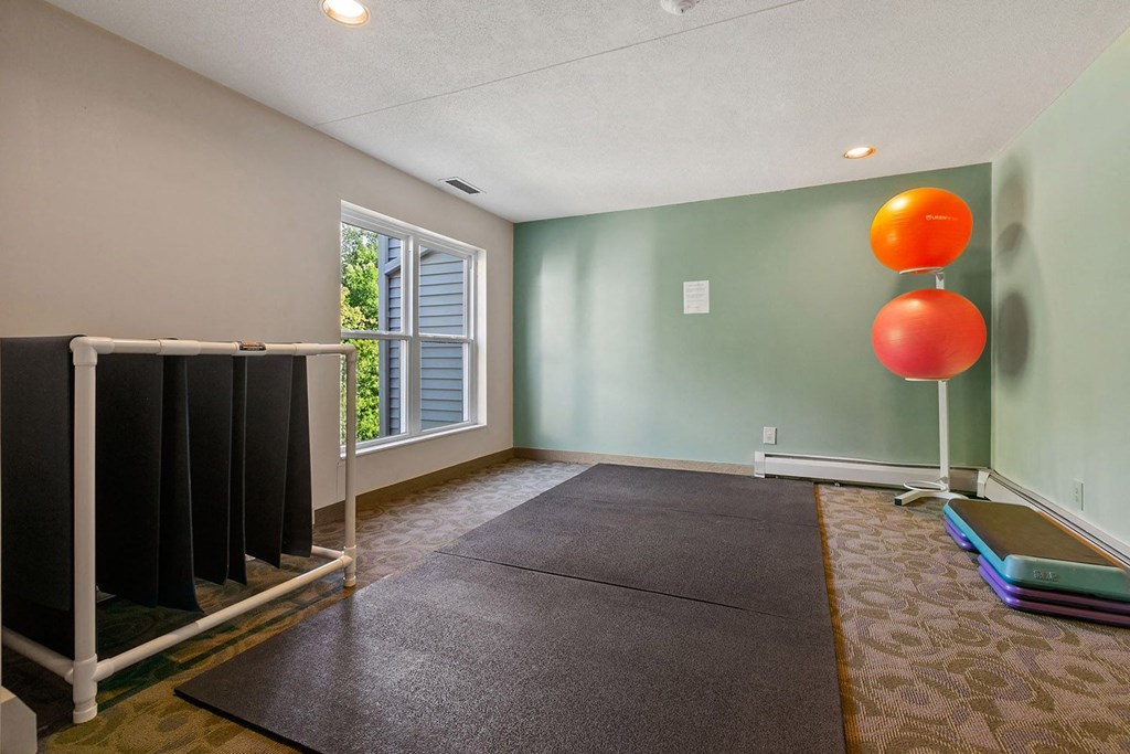 a room with a yoga mat and a balloon in the corner