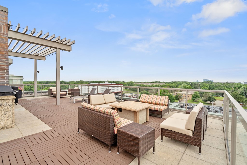 a rooftop terrace with wicker furniture and a view of the city