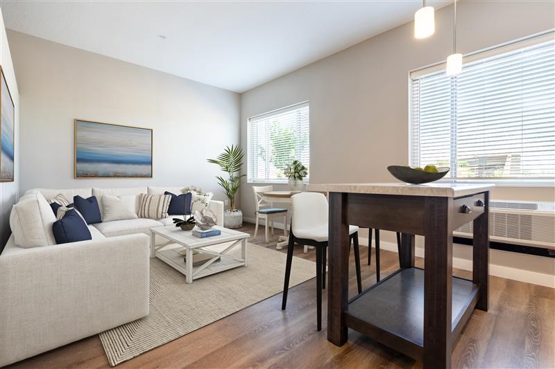 A living room with a white couch, a coffee table, and a painting on the wall.