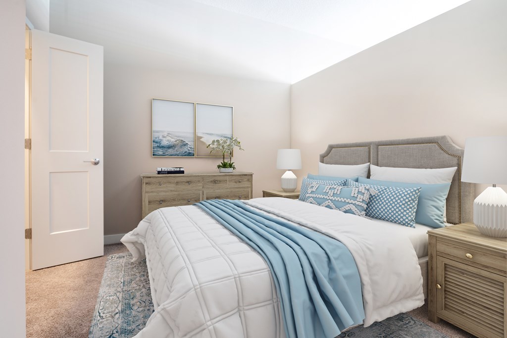 A bedroom with a large bed and a dresser with a mirror above it.