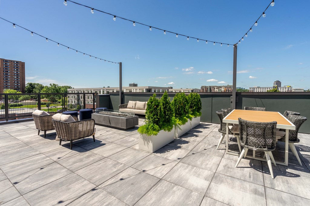 A rooftop patio with a table and chairs.