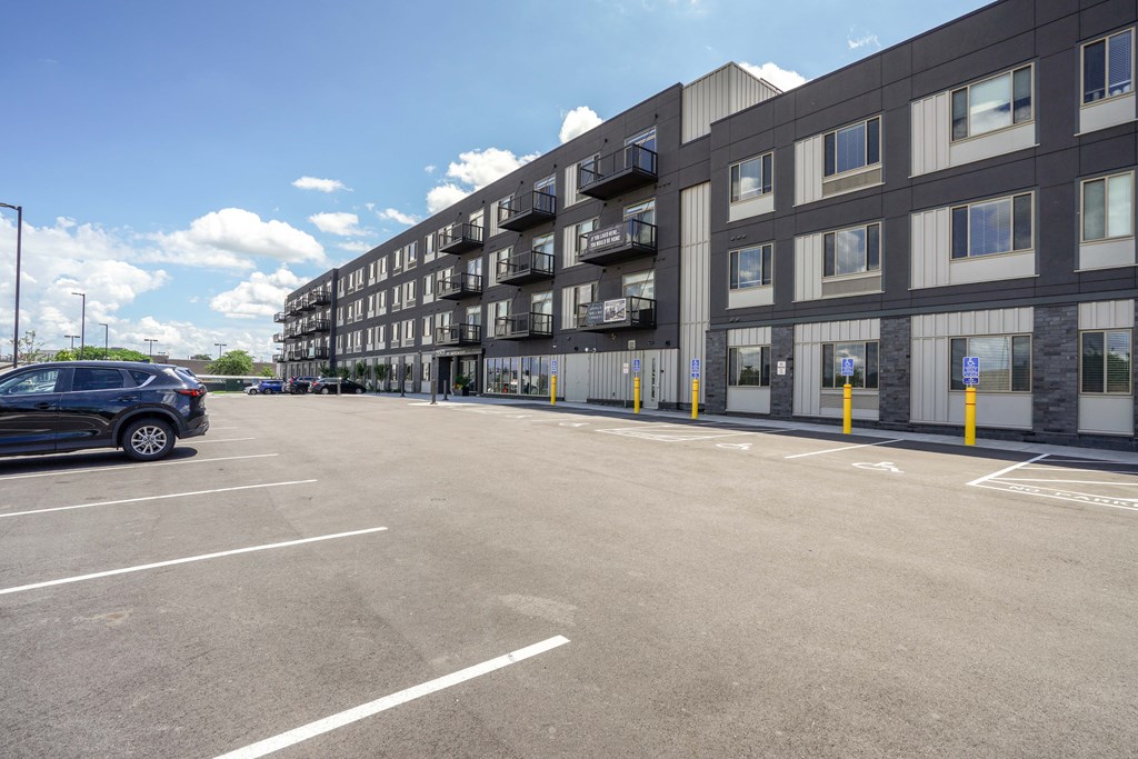 A parking lot in front of a multi-story building.