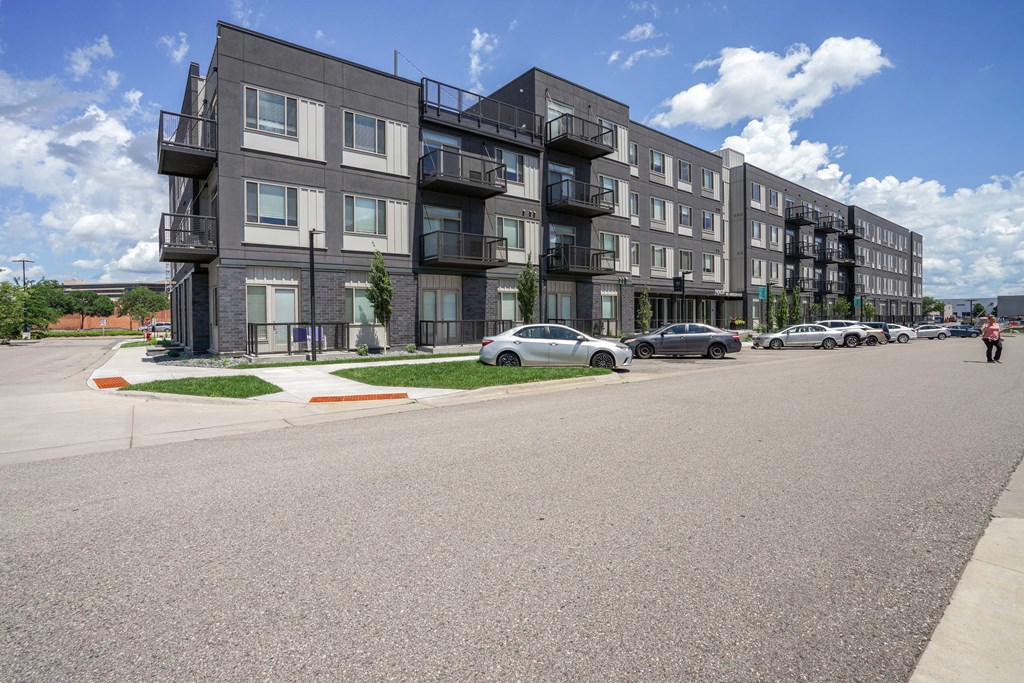 Apartment building with cars parked in front.