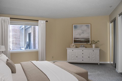 A bedroom with a large bed and a painting on the wall.