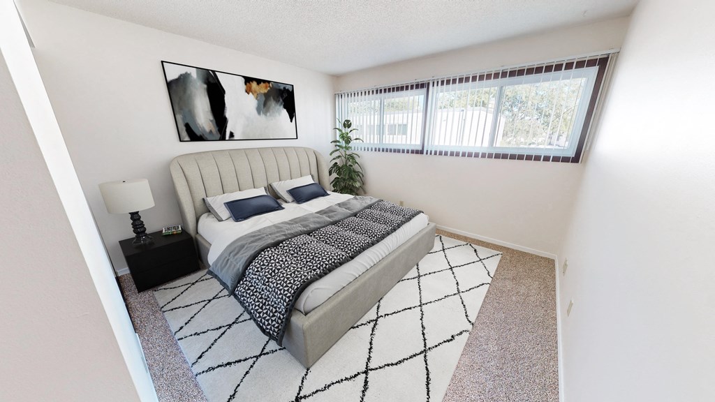 a bedroom with a bed and a large window