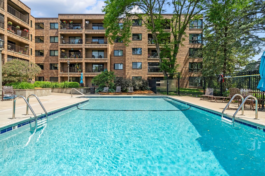 a swimming pool with an apartment building in the background