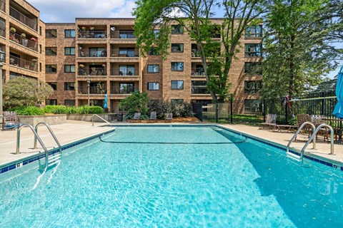 a swimming pool with an apartment building in the background