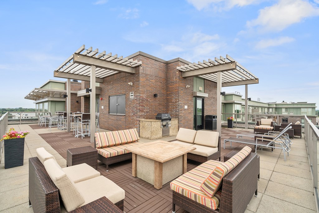 a patio with couches tables and chairs and a brick building