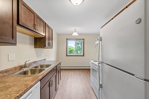 a kitchen with a sink and refrigerator and a window