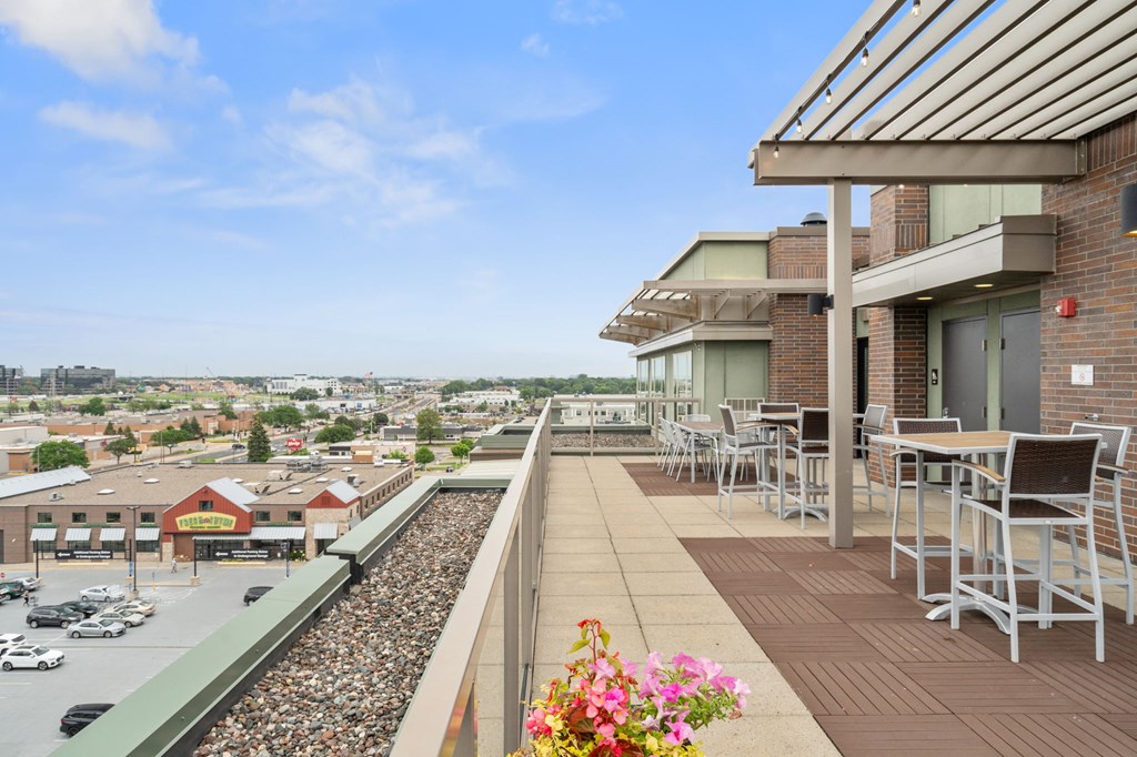 a balcony with tables and chairs and a view of the city