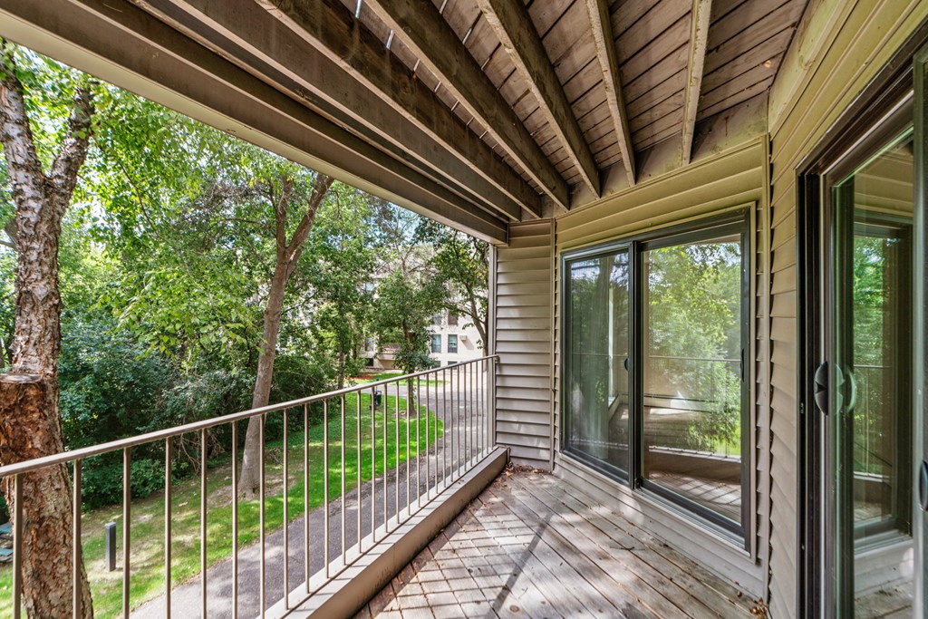 the screened in porch has a view of the yard and trees