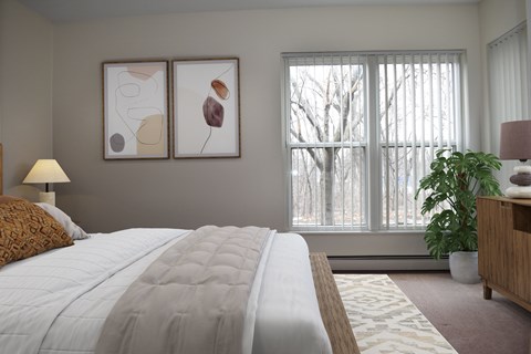 A bedroom with a large bed and two framed artworks on the wall.