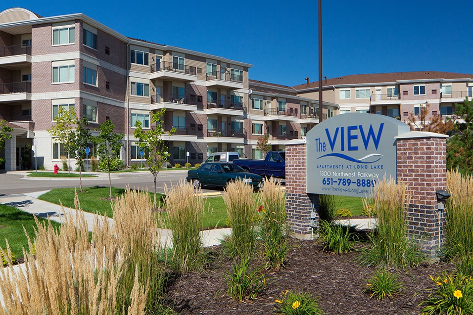 an apartment building with a sign in front of it