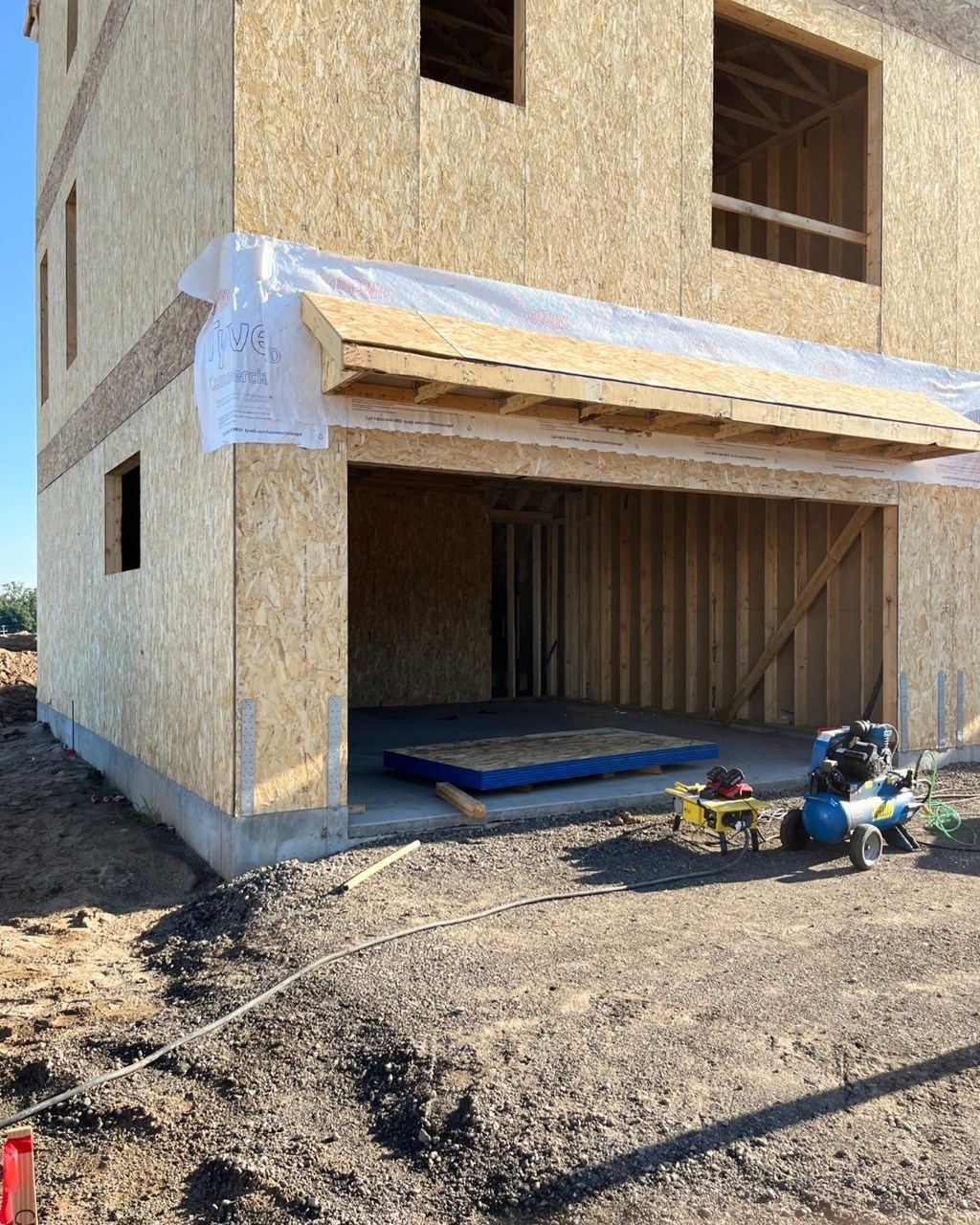 A house under construction with a roof covered in white insulation material.