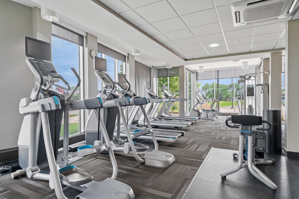 a room filled with cardio equipment and a large window