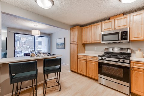 A kitchen with wooden cabinets and a stainless steel oven.