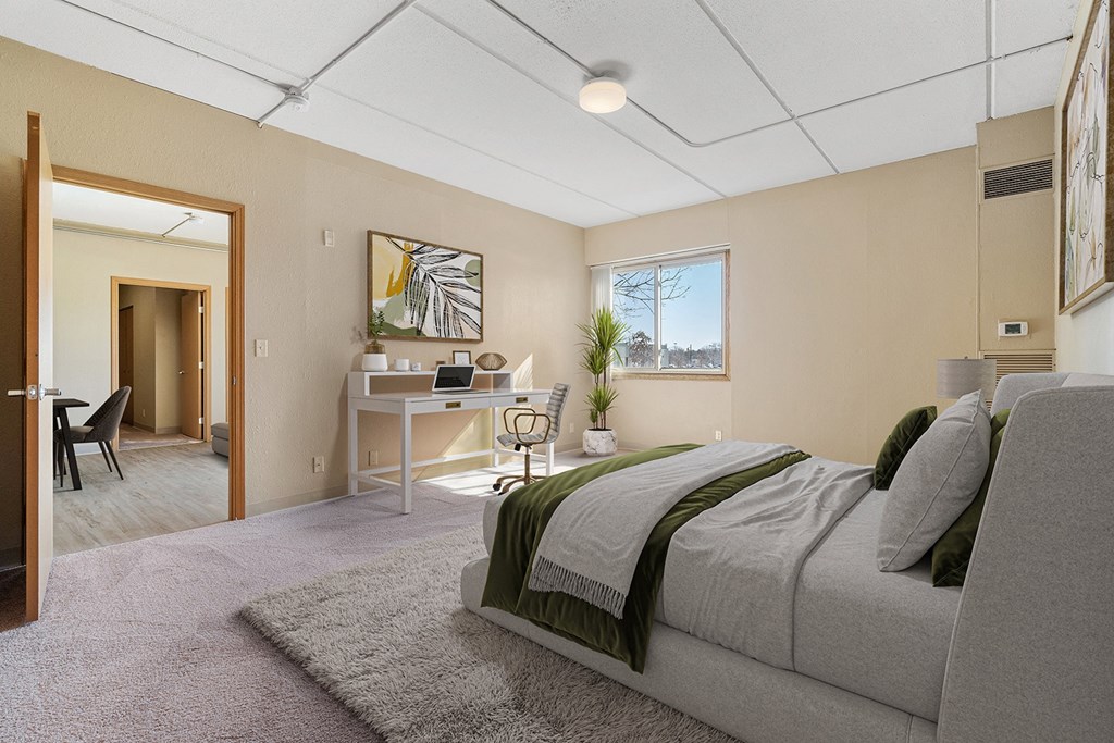 a bedroom with a bed and a desk with a chair