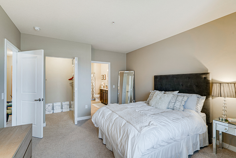 Bedroom with white comforters and bathroom and closet in frame