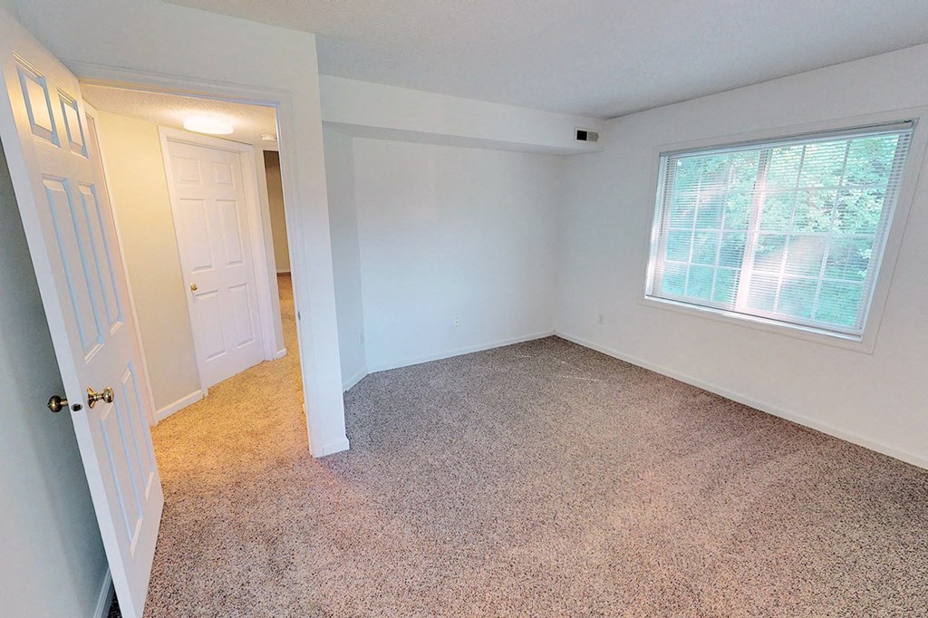 a bedroom with a large window and a white door