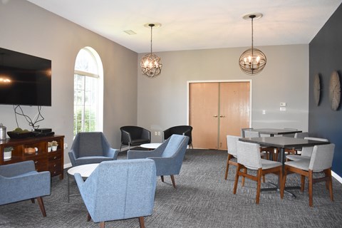 A living room with a grey carpet and a wooden dining table.