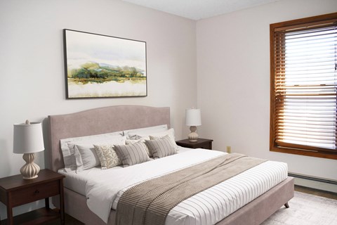 A bedroom with a large bed and a painting on the wall.