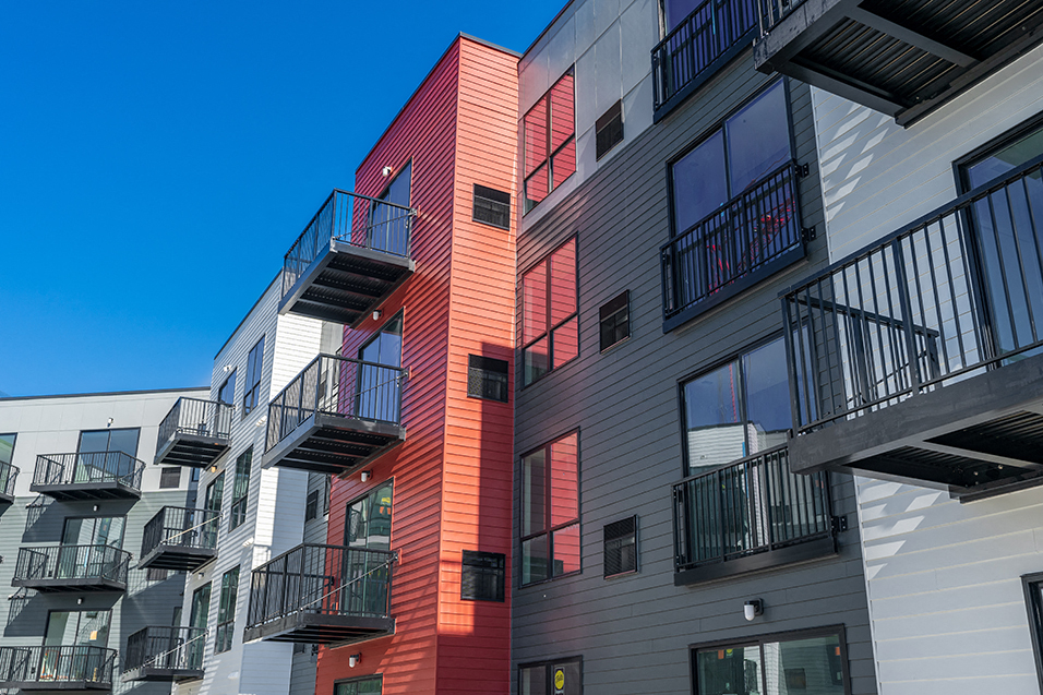 outside of red, gray, and white apartments with balconies