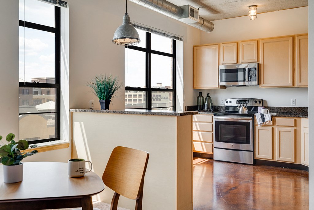 Kitchen with wood cupboards and a dining table in the foreground