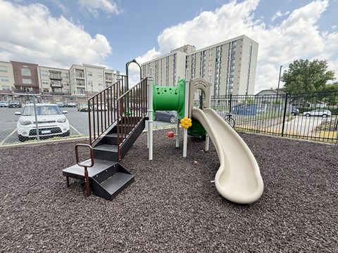 A playground with a slide, stairs, and a platform.