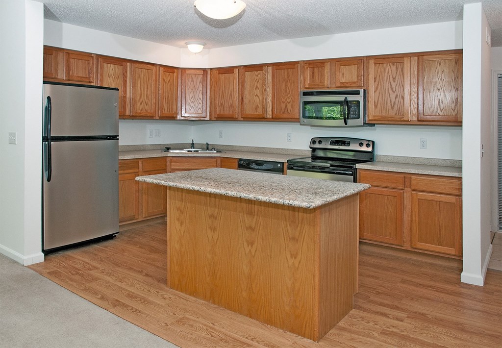 a kitchen with wooden cabinets and stainless steel appliances