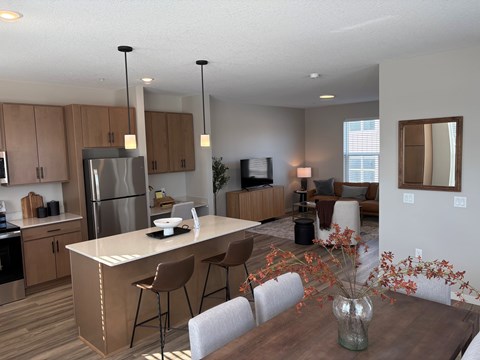 A modern kitchen with a dining table set for four.