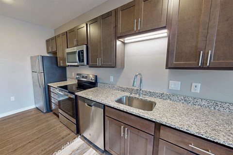 a kitchen with granite counter tops and stainless steel appliances
