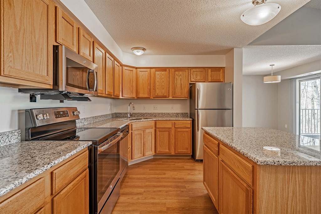 a kitchen with wooden cabinets and granite counter tops