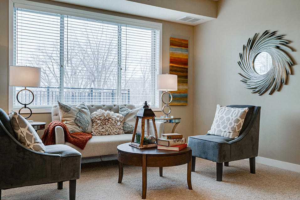 a living room with a couch and chairs and a window