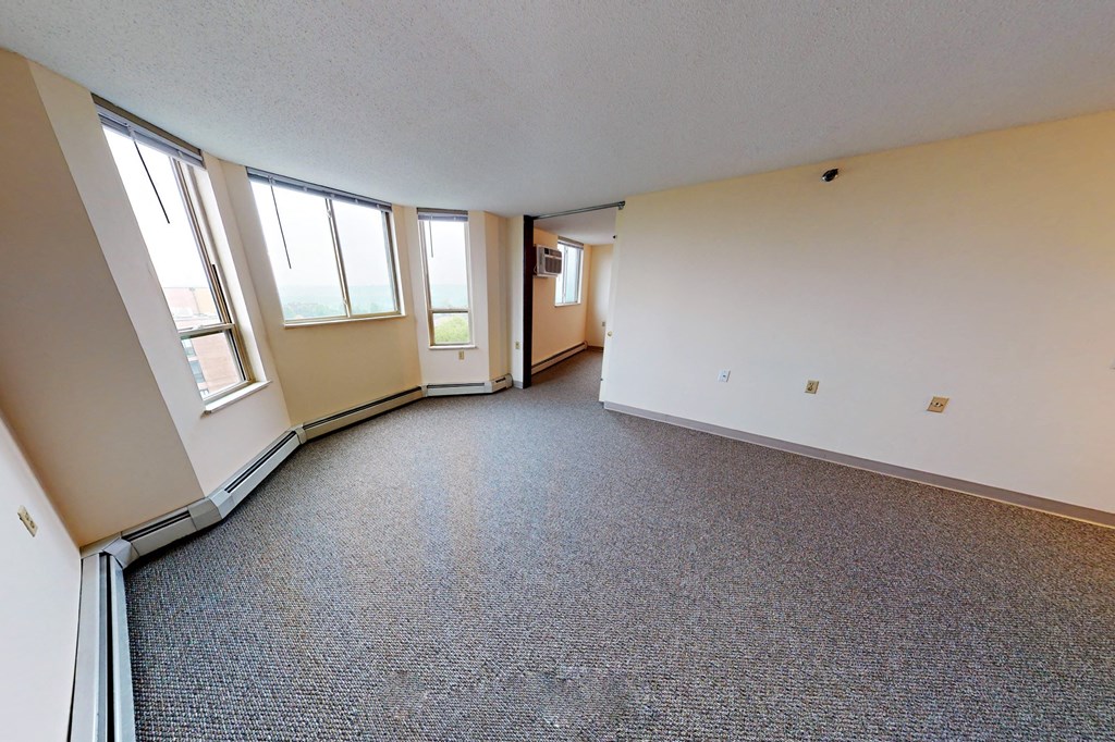 an empty room with three windows and a door