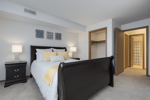 A bedroom with a large bed and a dresser.