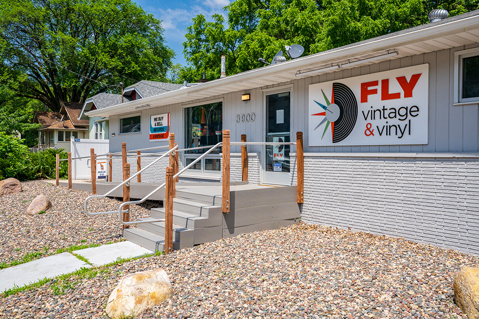 A small store with a sign that reads "FLY vintage & vinyl"