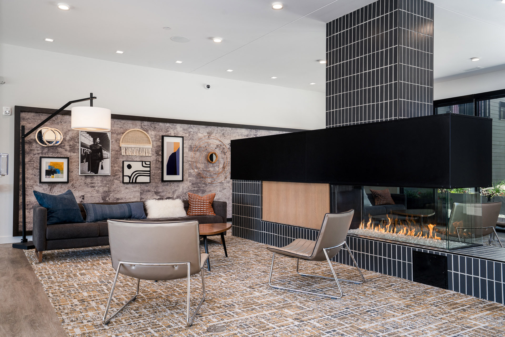 Lobby with a sofa and chairs and gas fireplace next to artwork