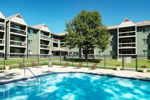 A swimming pool in front of apartment buildings.